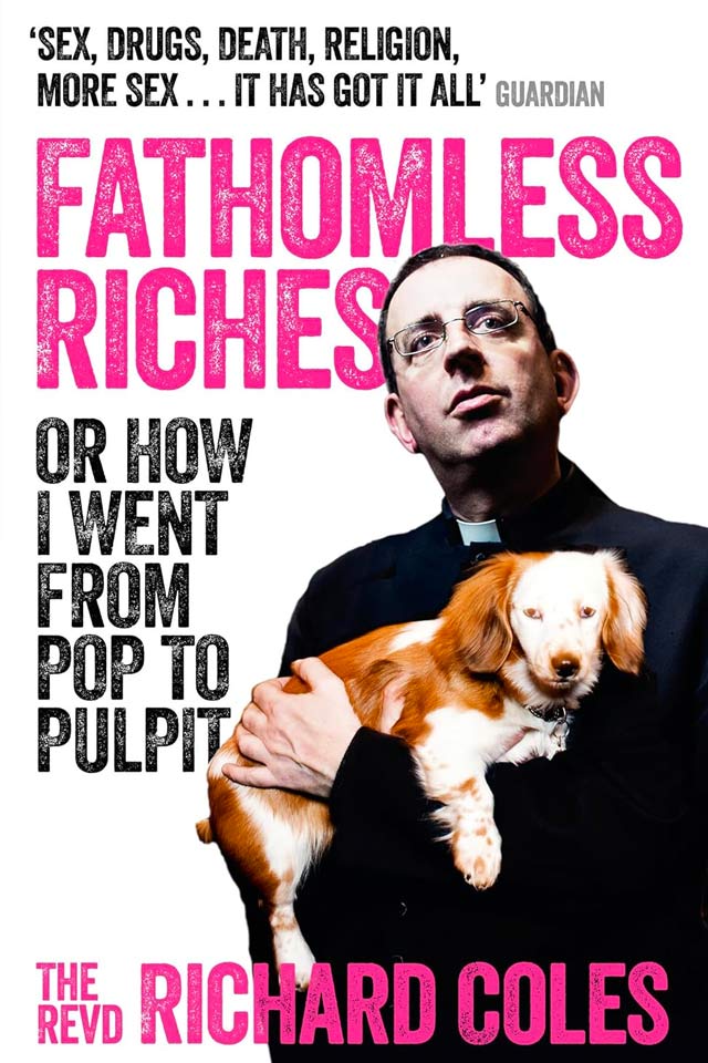 Waist length photo of Richard in a cassock holding a small dog in his arms. Cut out on white background.