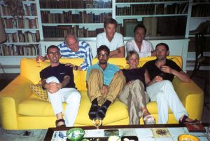 Celebrity holiday. Various celebs in a front room sat on a yellow sofa