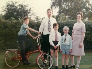 Family photo from the 70s. Richard, his parents and two brothers. Standing in the garden. One of the brother's is on a red bike