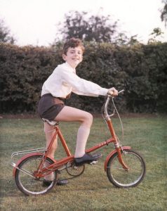 Richard as a kid, in the garden, on a red Raleigh RSW