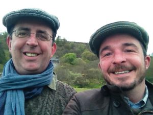 Outdoor photo of Richard (left) and David (right). Both tweed wearing flat caps