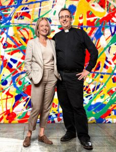 Mariella Frostrup standing with Richard in front of some kind of Jackson Pollock style mural